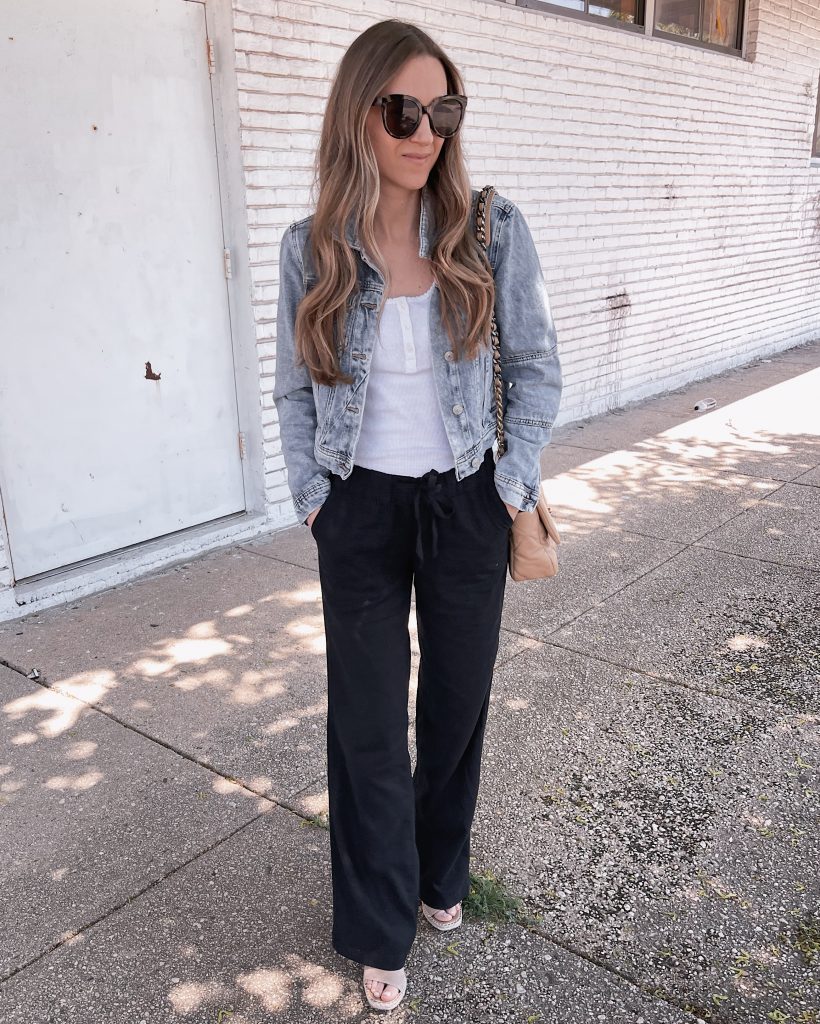 With white loose button down shirt, clutch, wide leg trousers and